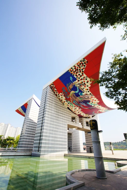 a building with a flag on top of it, a picture, inspired by Joong Keun Lee, cloisonnism, flying scarlet phoenix, covered outdoor stage, entrance, sangyeob park