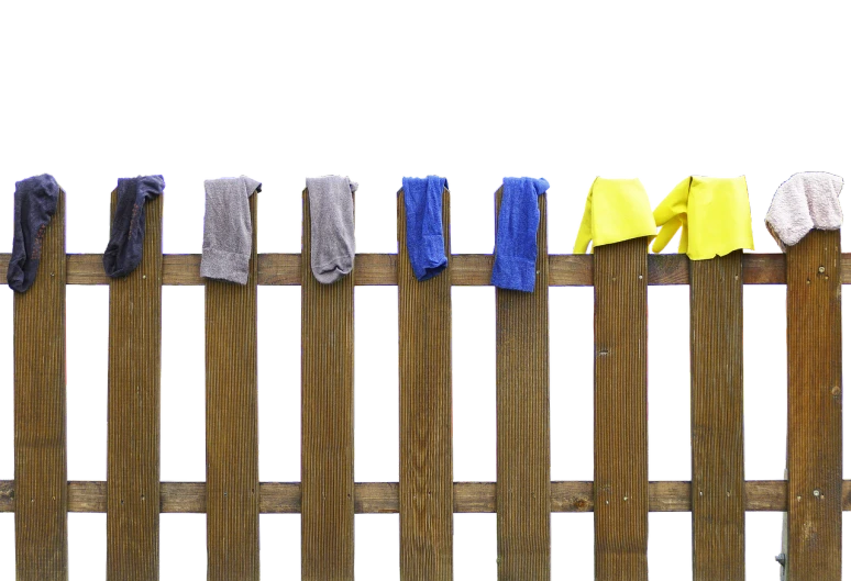 a wooden fence with clothes hanging on it, by Koloman Sokol, minimalism, on a black background, with yellow cloths, socks, details and vivid colors