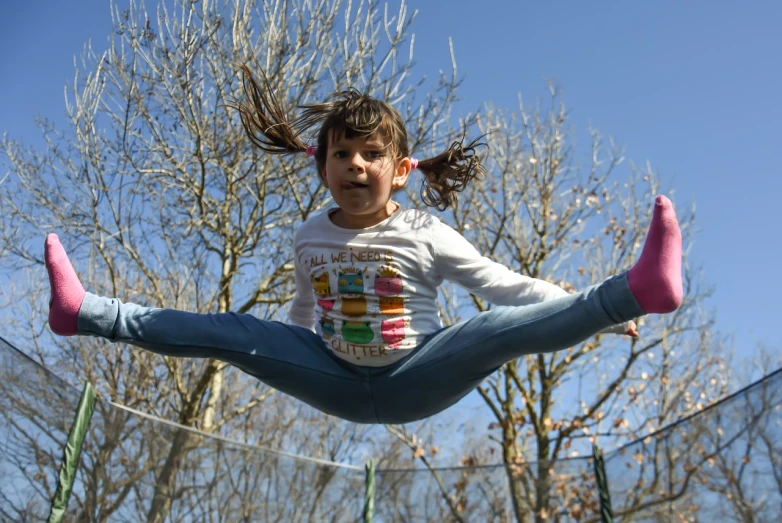 a young girl is jumping on a trampol, pexels contest winner, figuration libre, long pigtail, romanian, spring season, superhero