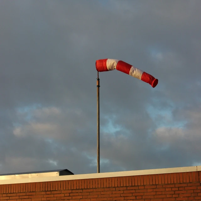 a red and white flag on top of a building, inspired by Jan Rustem, flickr, drainpipes, light cone, twister, photo 85mm