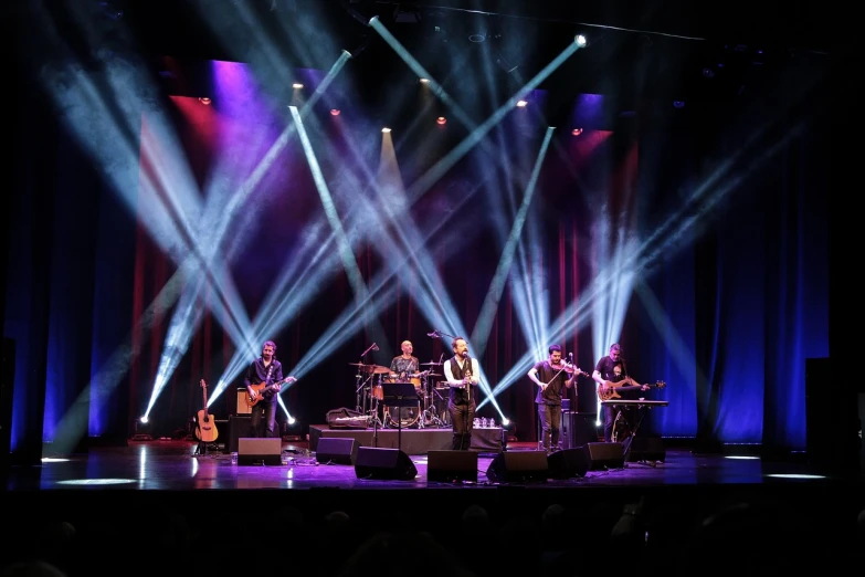 a group of people that are on a stage, by Jan Pynas, shutterstock, celtic, performing on stage, with professional lighting, bandoliers