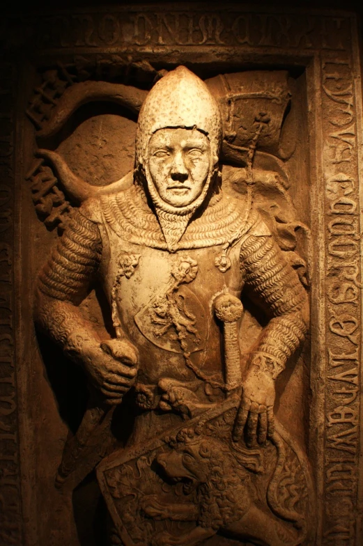 a statue of a man in armor holding a sword, by Thomas Tudor, flickr, inside a tomb, flat shaped stone relief, beautifully lit, face of an armored villian