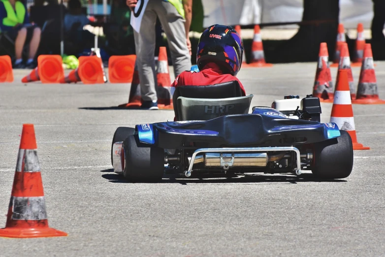 a person riding a go kart in a parking lot, a tilt shift photo, by Thomas Häfner, shutterstock, prototype car, in a race competition, photographed from behind, stock photo