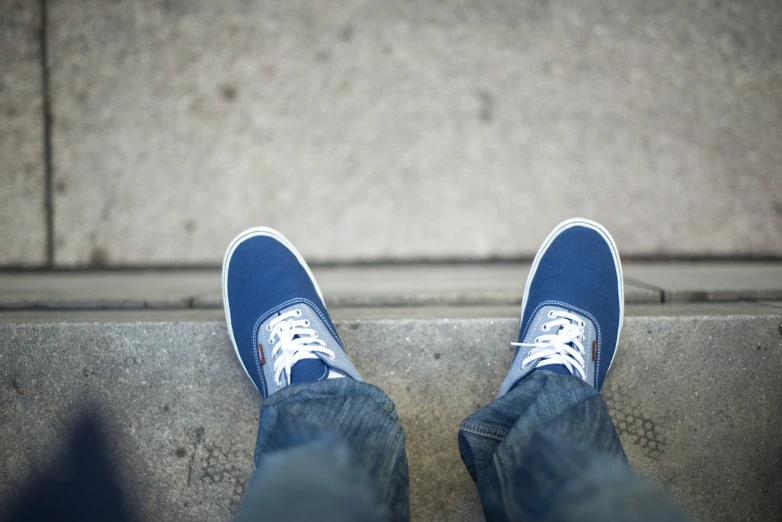 a person wearing blue and white tennis shoes, a picture, by Matt Stewart, waiting, acrophobia, photo taken with canon 5d, nerds