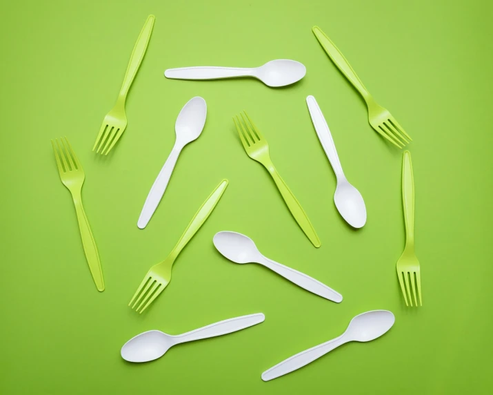 a group of forks and spoons arranged in a circle, shutterstock, plasticien, neon green, ivory, tundra, paper
