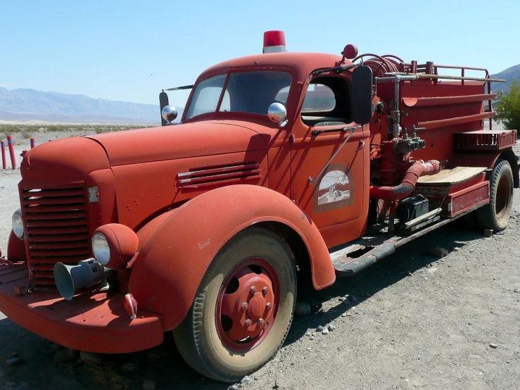 an old red fire truck parked on the side of the road, by Dennis Ashbaugh, flickr, death valley, soviet - era, not cropped, firefighting gear