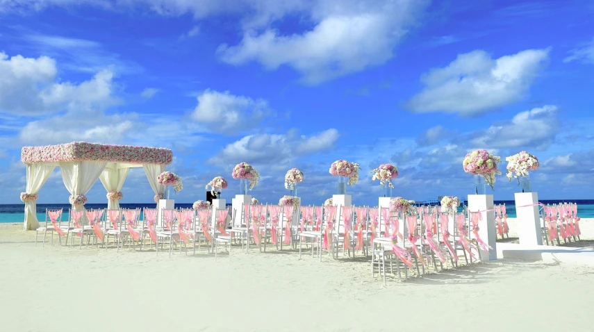 a wedding ceremony set up on the beach, a digital rendering, pixabay, baroque, the sky is pink, slightly sunny weather, hundreds of chairs and tables, [ cinematic