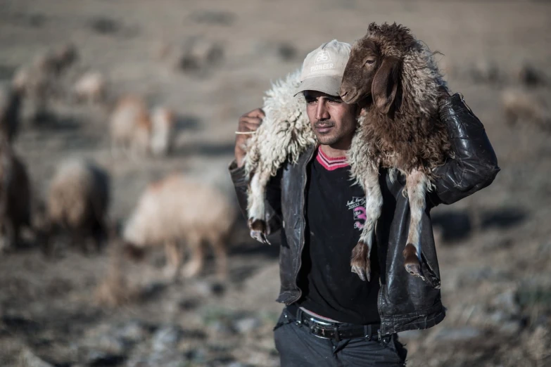 a man standing in front of a herd of sheep, a portrait, romanticism, an afghan male type, clasps his bangs in one hand, working, very sharp photo