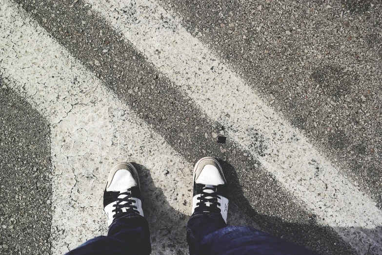 a person standing on a street with their shoes on, inspired by Alexander Rodchenko, crossing the line, on a bright day, lowres, steps