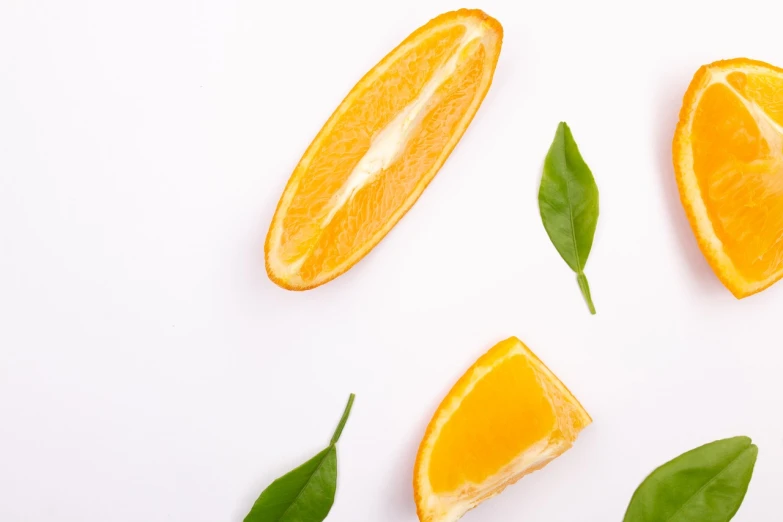 a group of sliced oranges sitting on top of a white surface, pexels, realism, leaf, background image, productphoto, banner