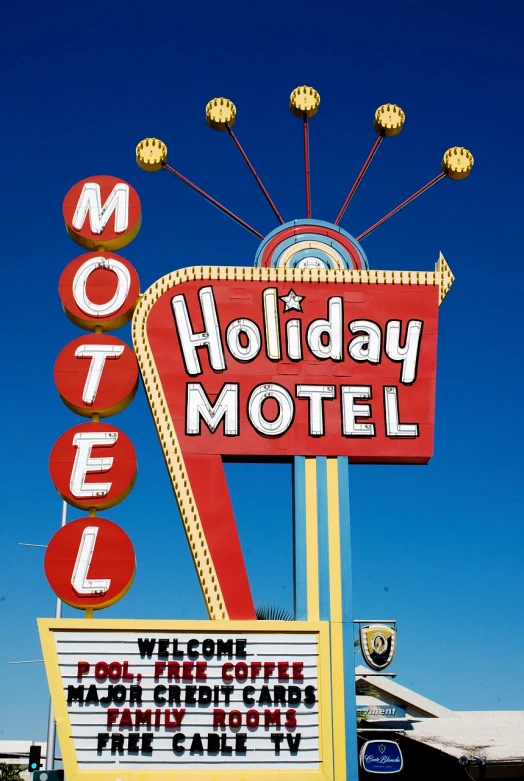 a motel sign in front of a blue sky, a photo, holiday season, high res photo, advertisement photo, elaborate detail