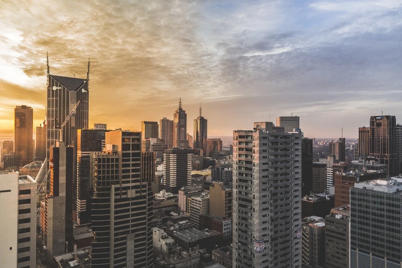 a view of a city from the top of a building, by Alexander Robertson, pexels contest winner, modernism, melbourne, suns, buildings covered with greebles, end of the day