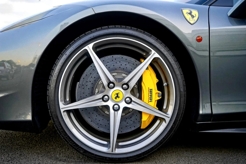 a close up of a wheel on a sports car, a picture, inspired by Bernardo Cavallino, ferrari 458, flat grey color, yellow details, vehicle photography