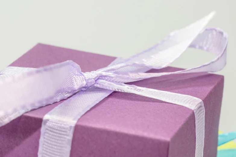 a purple gift box with a white ribbon, by Eden Box, pexels, modernism, photorealistic detail, sandra chevier, close up angle, birthday