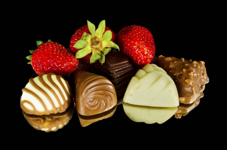 a close up of chocolates and strawberries on a black background, 3 4 5 3 1