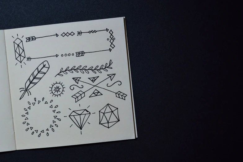 a close up of a book with drawings on it, tumblr, “diamonds, tribal tattoos, flash sheet, very minimalistic