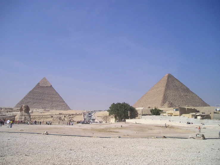 a group of people standing in front of three pyramids, egyptian art, renaissance, photo taken from far away, two giant towers, blue sky, wikimedia