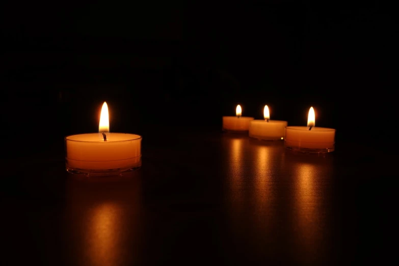 a group of lit candles sitting on top of a table, a picture, minimalism, night photo