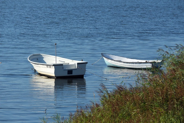 a couple of boats floating on top of a lake, a photo, dau-al-set, hot summer day, portlet photo, morning detail, file photo