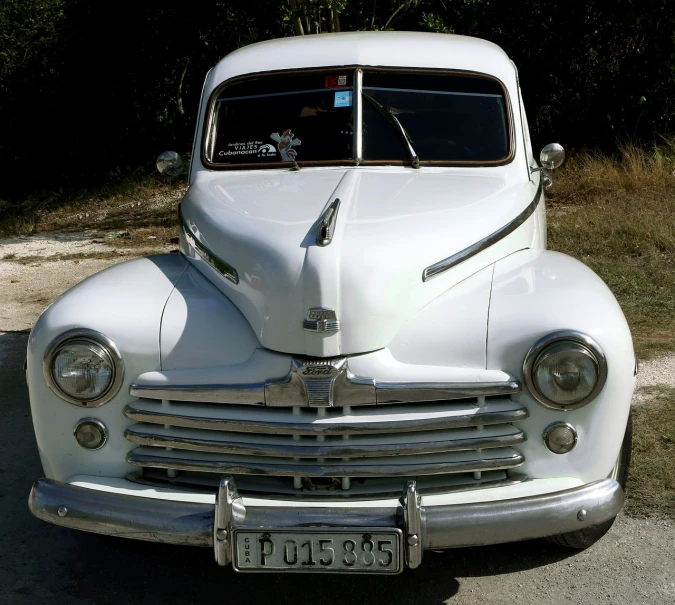 an old white car parked on the side of the road, a portrait, by Arnie Swekel, flickr, bauhaus, jamaica, symmetrical front view, vintage - w 1 0 2 4, mercury