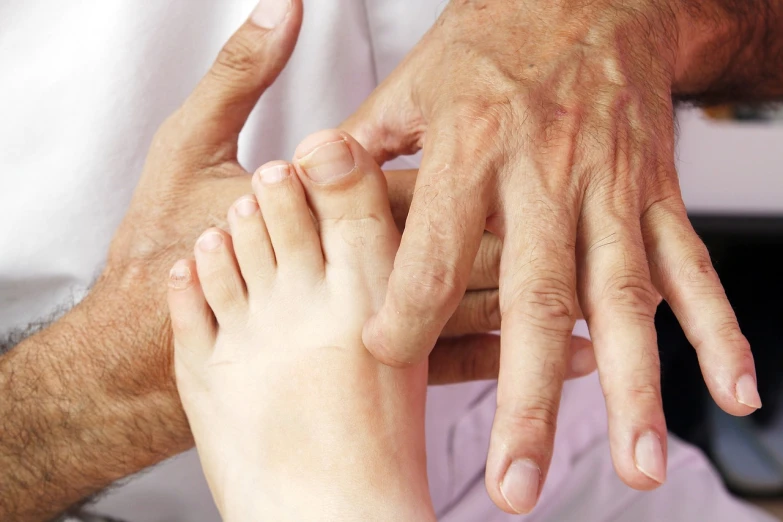 a close up of a person holding a child's hand, by Victorine Foot, local conspirologist, giant kicking foot, portrait of hide the pain harold, older male