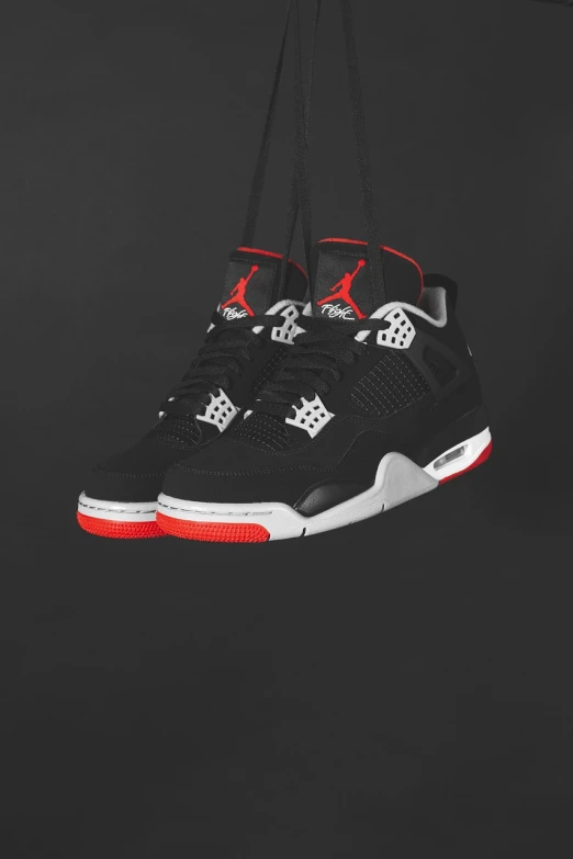 a pair of shoes hanging from a string, inspired by Jordan Grimmer, hq 4k phone wallpaper, black red white clothes, tri - x 4 0 0, black steel with red trim