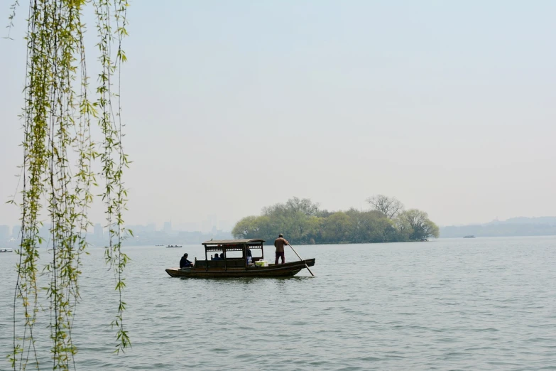 a man standing on top of a boat in a body of water, a picture, by Li Zai, flickr, mingei, parks and lakes, perfect spring day with, seen from a distance, beijing