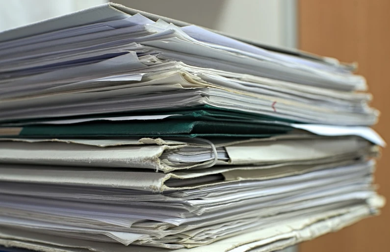 a stack of papers sitting on top of a desk, by Thomas Häfner, view from below, single file, covered, many details