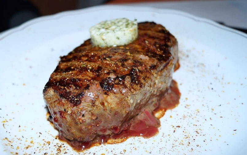 a piece of steak sitting on top of a white plate, flickr, butter, gooey, profile image, close-up!!!!!!