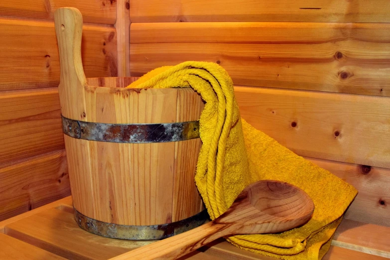 a wooden bucket sitting on top of a wooden shelf, shutterstock, wearing a towel, with yellow cloths, log homes, bubbling skin