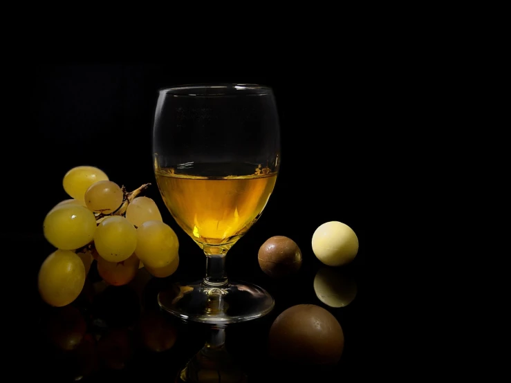 a glass of wine next to a bunch of grapes, tonalism, translucent eggs, glass with rum, high quality product photo