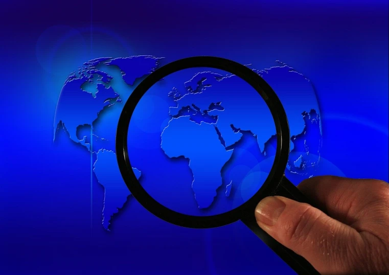a close up of a person holding a magnifying glass, a microscopic photo, world map, reportage photo, dsrl photo, blue image