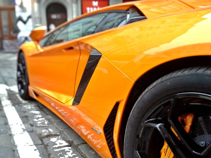 an orange sports car parked on the side of the road, a picture, pexels, precisionism, extreme detail 4 k, yellow and black, 🦩🪐🐞👩🏻🦳, view from the streets