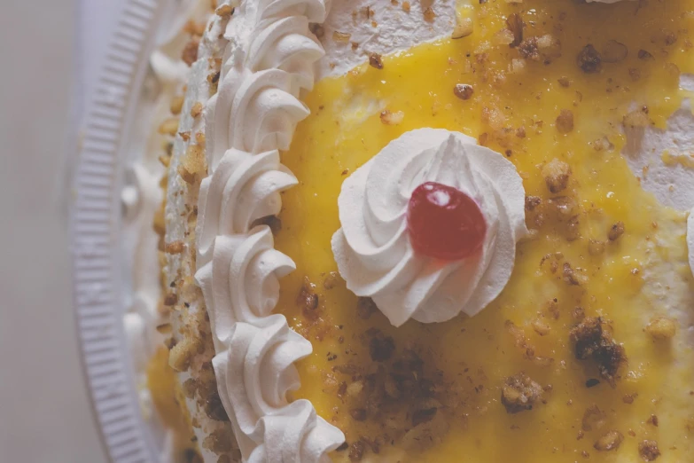 a cake with whipped cream and a cherry on top, a picture, by Dan Frazier, pexels, renaissance, yellow, close-up from above, william eggleston, 4 k detail