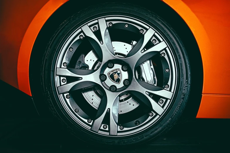 a close up of a wheel on an orange sports car, by Thomas Häfner, cg society contest winner, renaissance, highly detailed product photo, perfect symmetrical image, detailed product photo, catalog photo