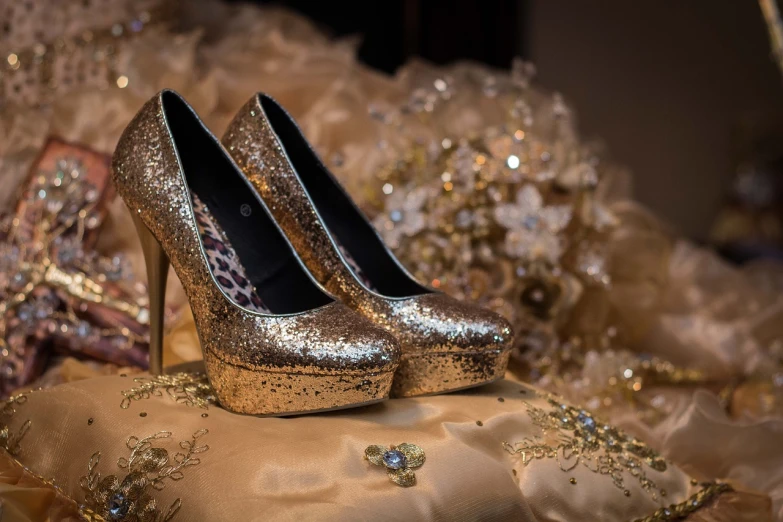 a pair of gold shoes sitting on top of a pillow, by Maksimilijan Vanka, pixabay contest winner, floral bling, topaz and other jewellaries, glitter dress, photo session