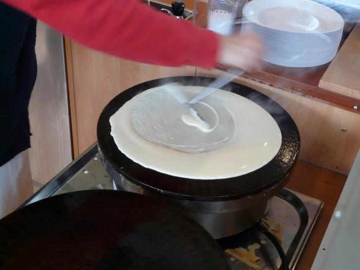 a person pouring something into a pot on top of a stove, by Dietmar Damerau, flickr, hurufiyya, pancake flat head, white wax, chiffon, switzerland