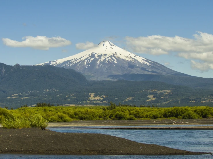 a mountain in the distance with a body of water in the foreground, a portrait, by Juan O'Gorman, flickr, lava river, 1128x191 resolution, with snow on its peak, wikimedia commons