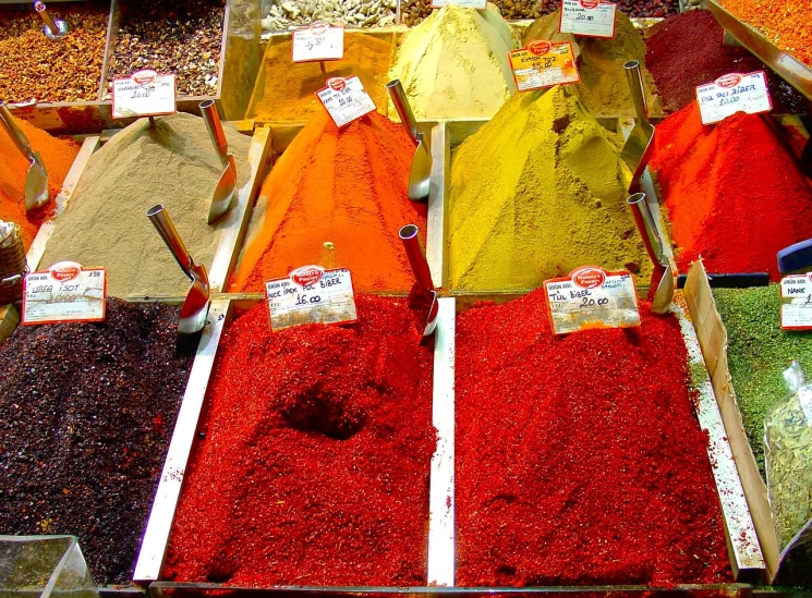 a display case filled with lots of different colored spices, by Dietmar Damerau, flickr, turkey, red and yellow color scheme, deep colours. ”