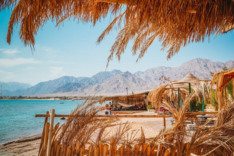a view of a beach with mountains in the background, a picture, by Whitney Sherman, pexels, sukkot, egyptian style, 🕹️ 😎 🔫 🤖 🚬, summer feeling