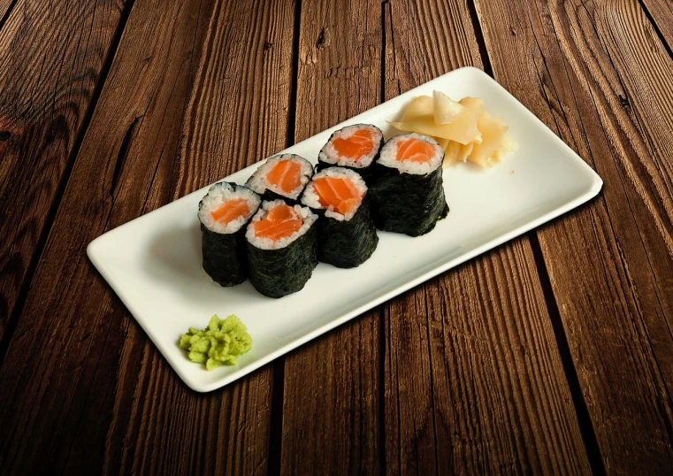 a white plate topped with sushi on top of a wooden table, a picture, inspired by Maki Haku, professional product photo, salmon khoshroo, great quality ), ilya kushinov