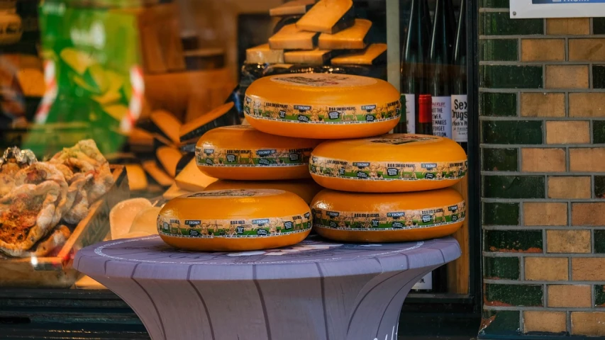 a bunch of cheese stacked on top of each other, a picture, by Dietmar Damerau, pexels, dutch landscape, spherical, sitting on a store shelf, around the city