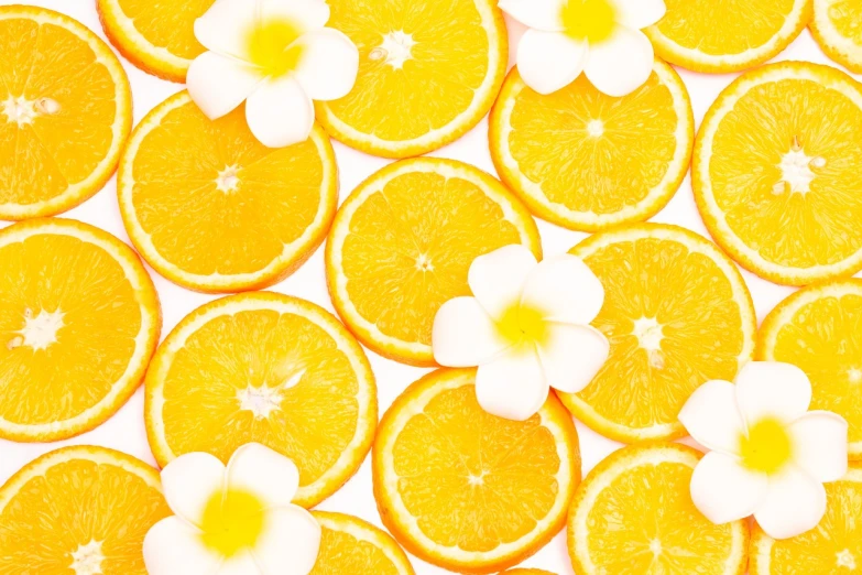 a bunch of orange slices with flowers on them, a stock photo, by Tadashi Nakayama, trending on shutterstock, art deco, plumeria, white and yellow scheme, patterned background, high angle close up shot