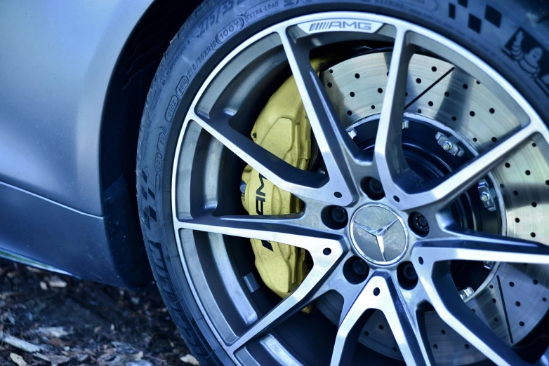 a close up of a wheel on a car, a picture, by Thomas Häfner, pexels, photorealism, mercedez benz, yellow details, ears, hyperdetailed!!