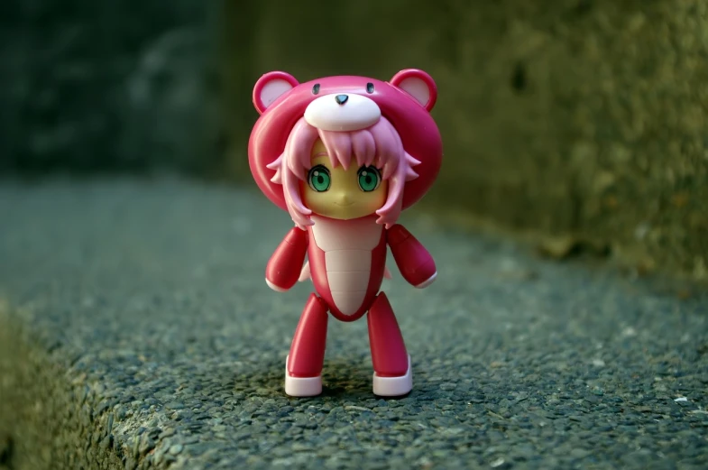 a close up of a toy on a concrete surface, inspired by Hiromu Arakawa, flickr, pathfinder nendoroid, miniature bear, full body zenkai! asuka suit, pink tigers