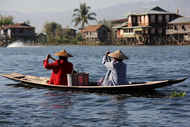 a couple of people riding on top of a boat, flickr, mingei, asian women, in the middle of a lake, reuters, myanmar