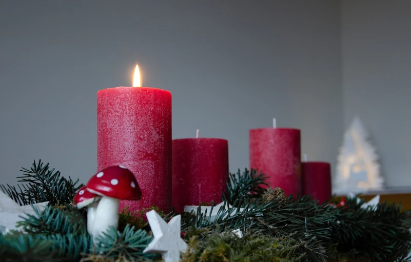 a group of red candles sitting on top of a table, by Anna Haifisch, pexels, amanita muscaria, christmas, avatar image, chalk