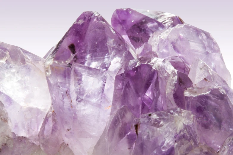 a cluster of purple crystals sitting on top of a white surface, shutterstock, dynamic closeup, amethyst stained glass, a wide full shot, close-up product photo