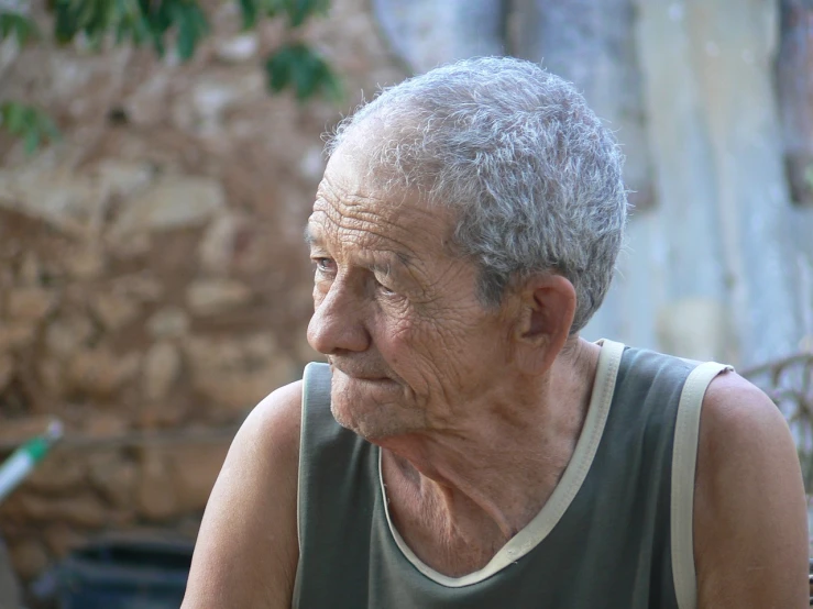 a close up of a person sitting at a table, a portrait, by Juan Giménez, old village, mature male, looking across the shoulder, elderly greek goddess