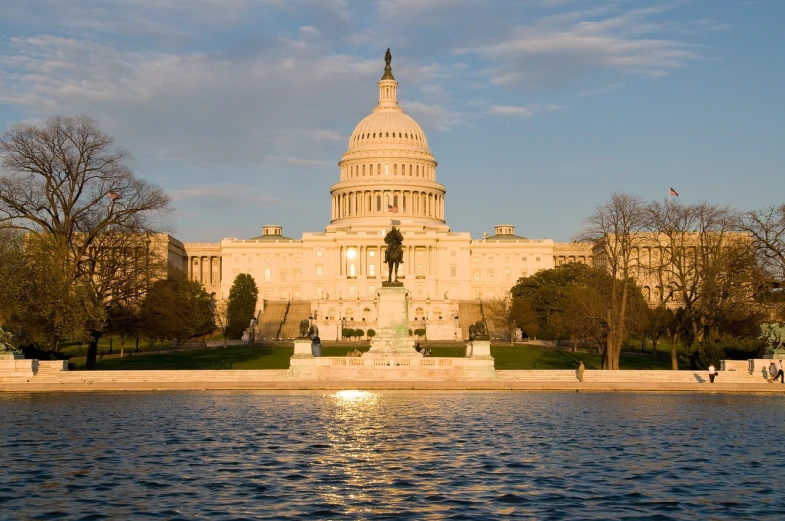 a large building with a fountain in front of it, a picture, by Joseph Raphael, flickr, capitol building, golden hour”, lakeside, small stature